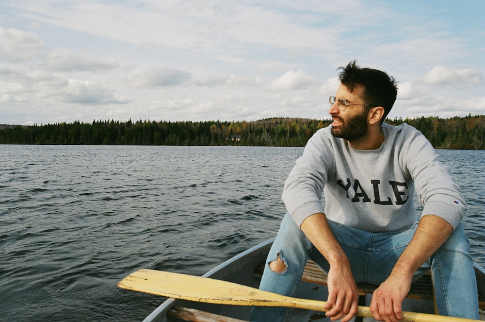 man in white crew neck t-shirt sitting on white boat during daytime