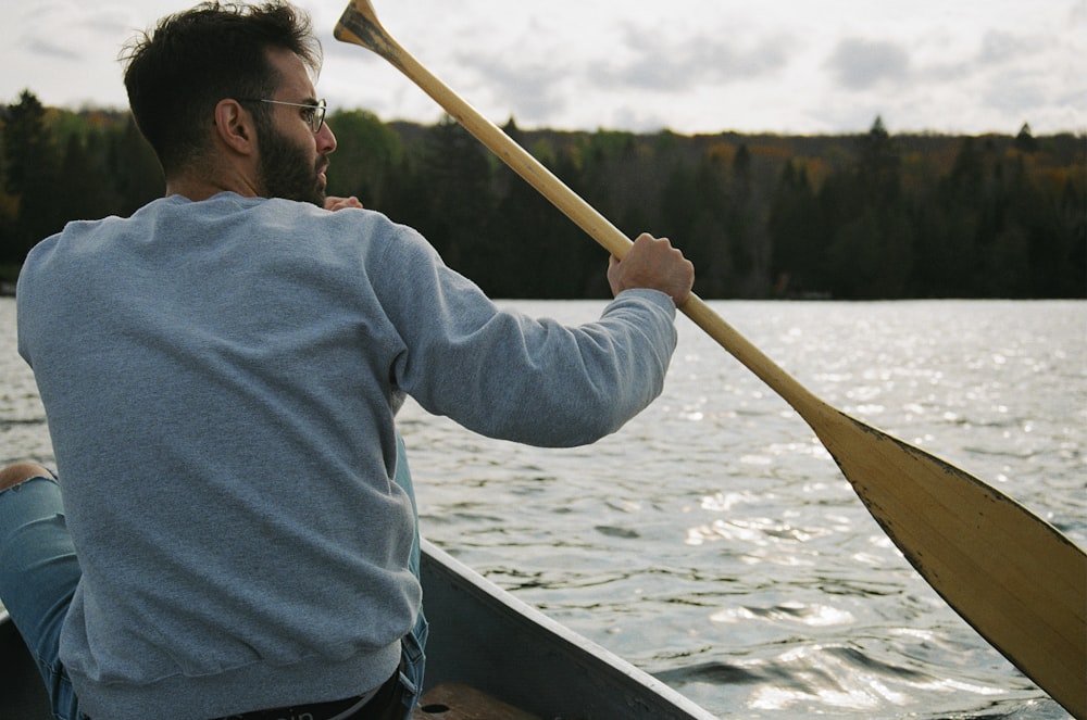 man in blue hoodie riding on boat during daytime
