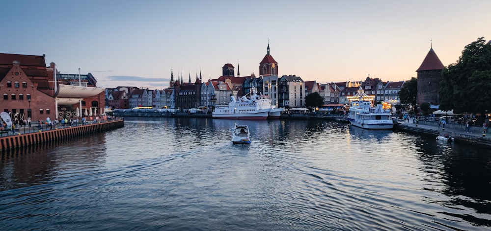 white and brown boat on water near city buildings during daytime