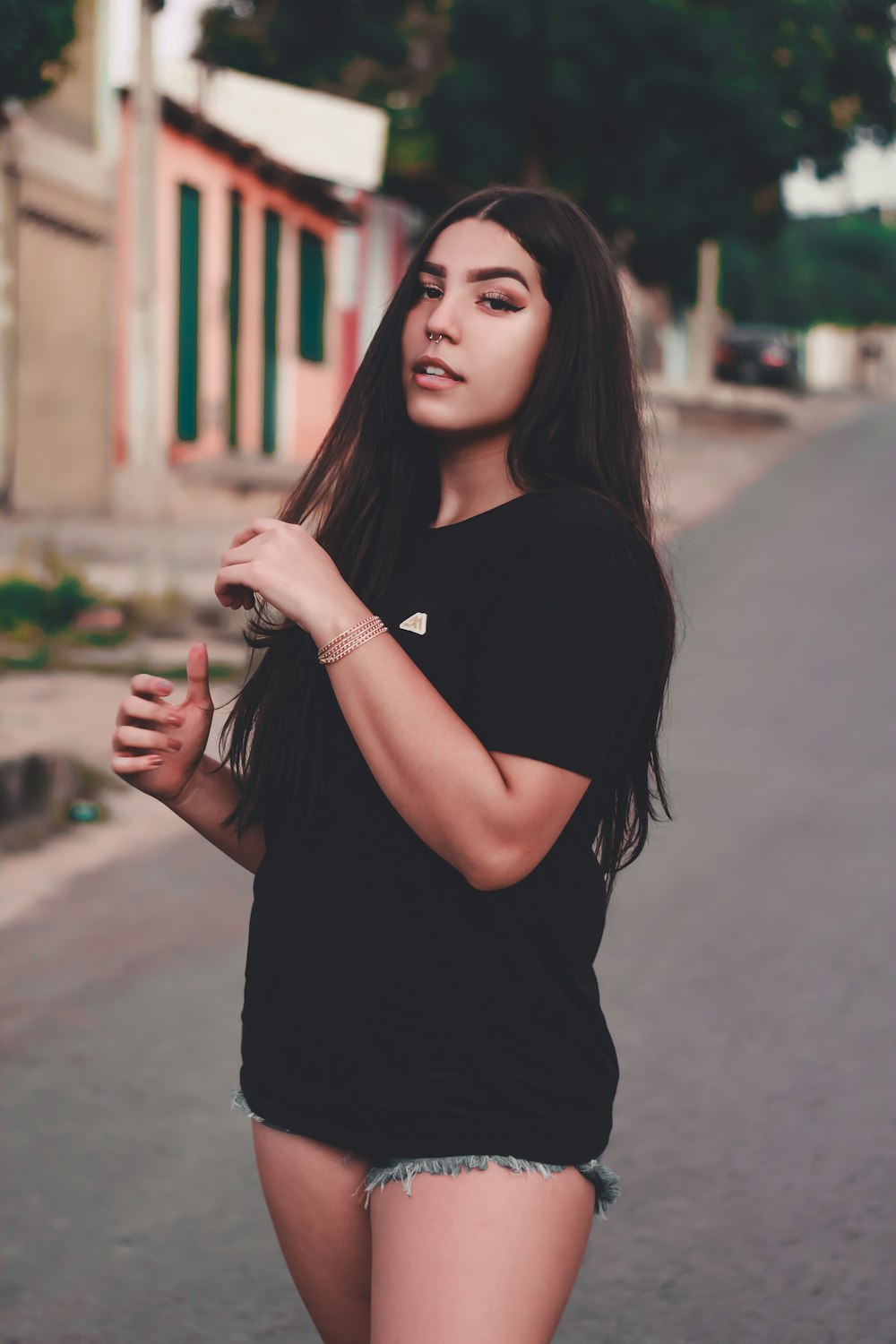 woman in black crew neck t-shirt standing on road during daytime