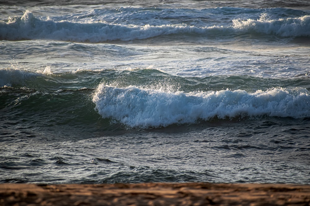 ocean waves crashing on shore during daytime