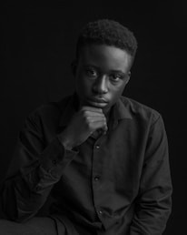 Portrait of Nima Sina in a thoughtful pose against a simple background.