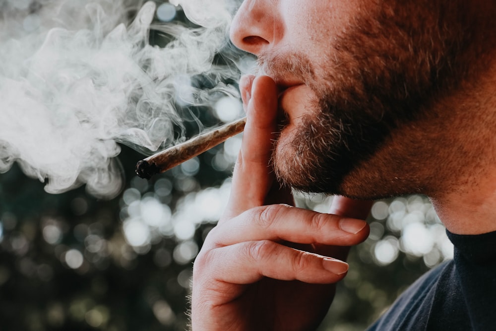 Hombre fumando cigarrillo durante el día