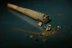 A tightly rolled joint is placed on a dark surface, with scattered bits of cannabis around it. The focus is on the contents of the joint, highlighting the texture and color of the marijuana.