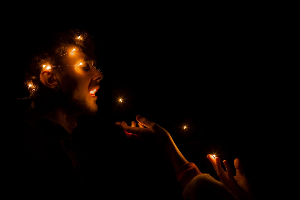 woman in brown long sleeve shirt holding lighted candle