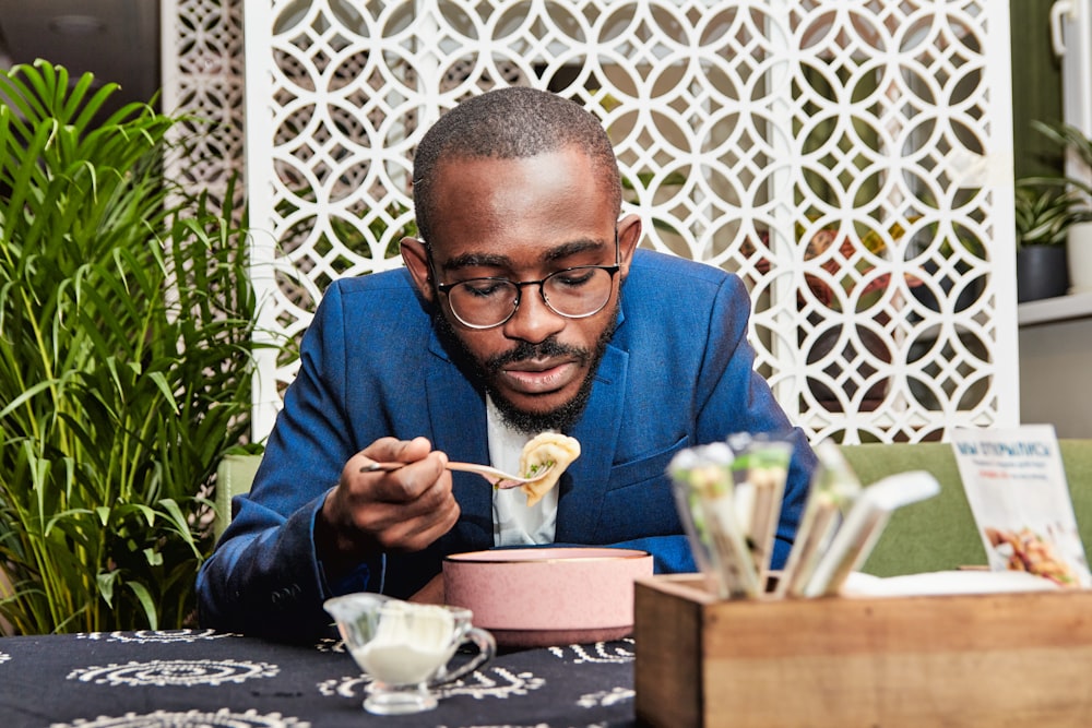 man in blue suit jacket holding white ceramic mug