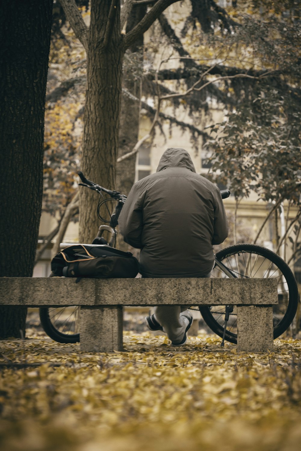 man in brown jacket sitting on bench