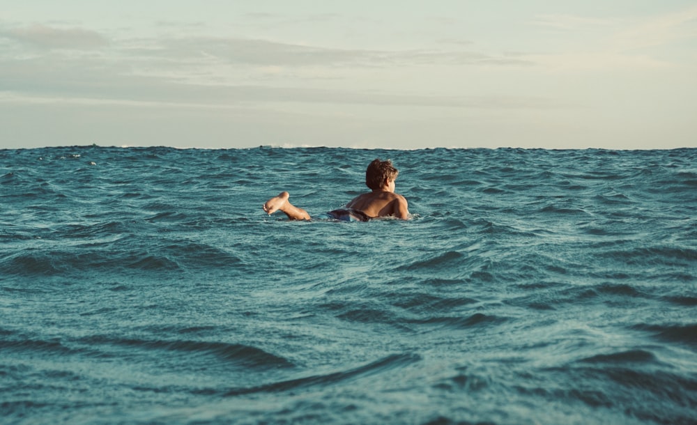 man in blue water during daytime