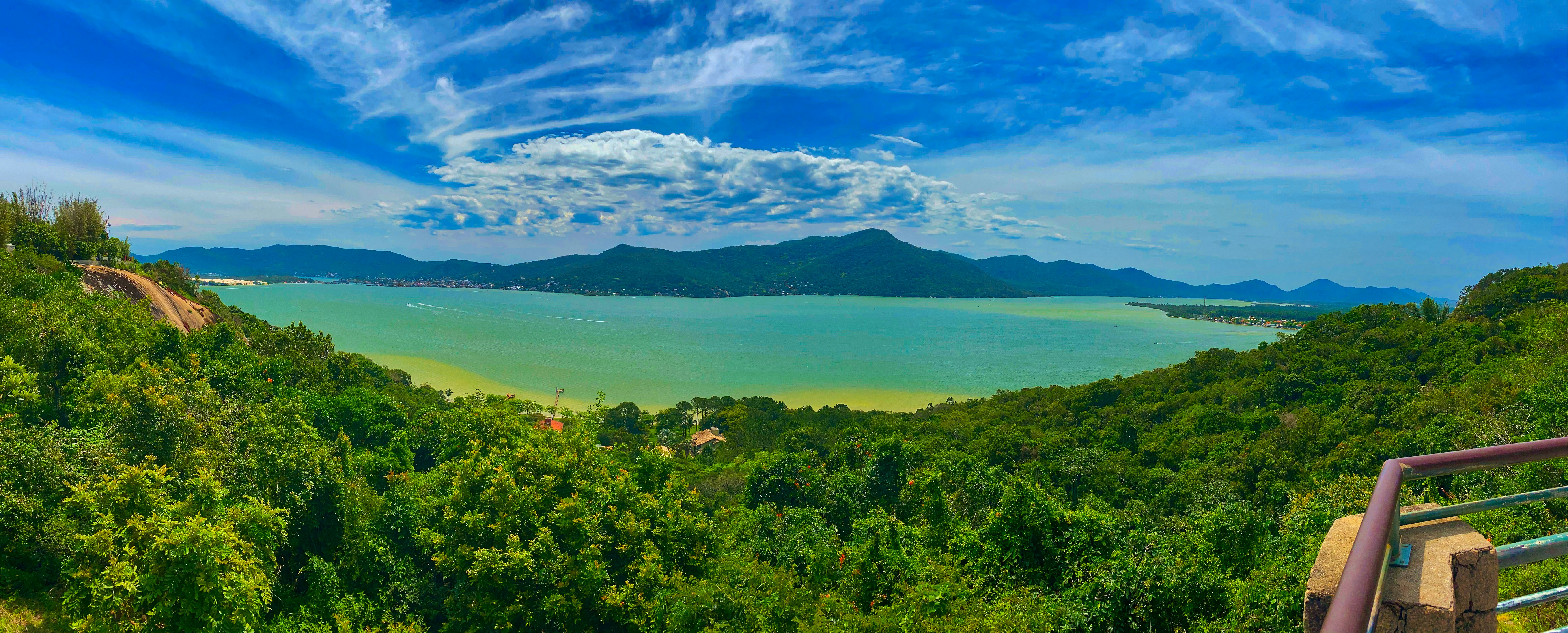 Fethiye marina and turquoise bay viewed from hillside, lush green mountains, blue sky with light clouds