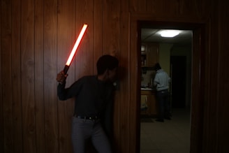 man in black long sleeve shirt holding red and white stick