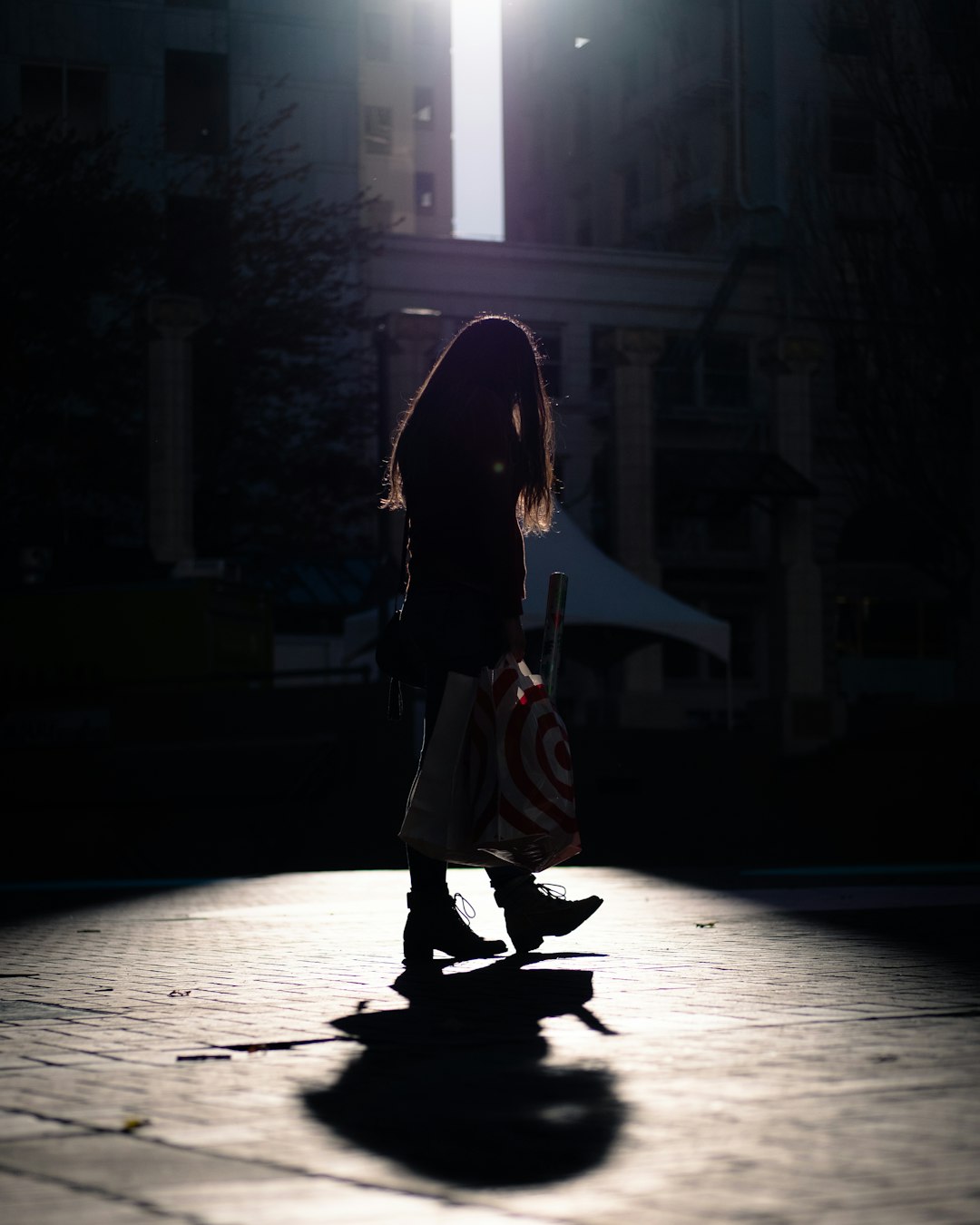 woman in black jacket and brown skirt walking on street during night time
