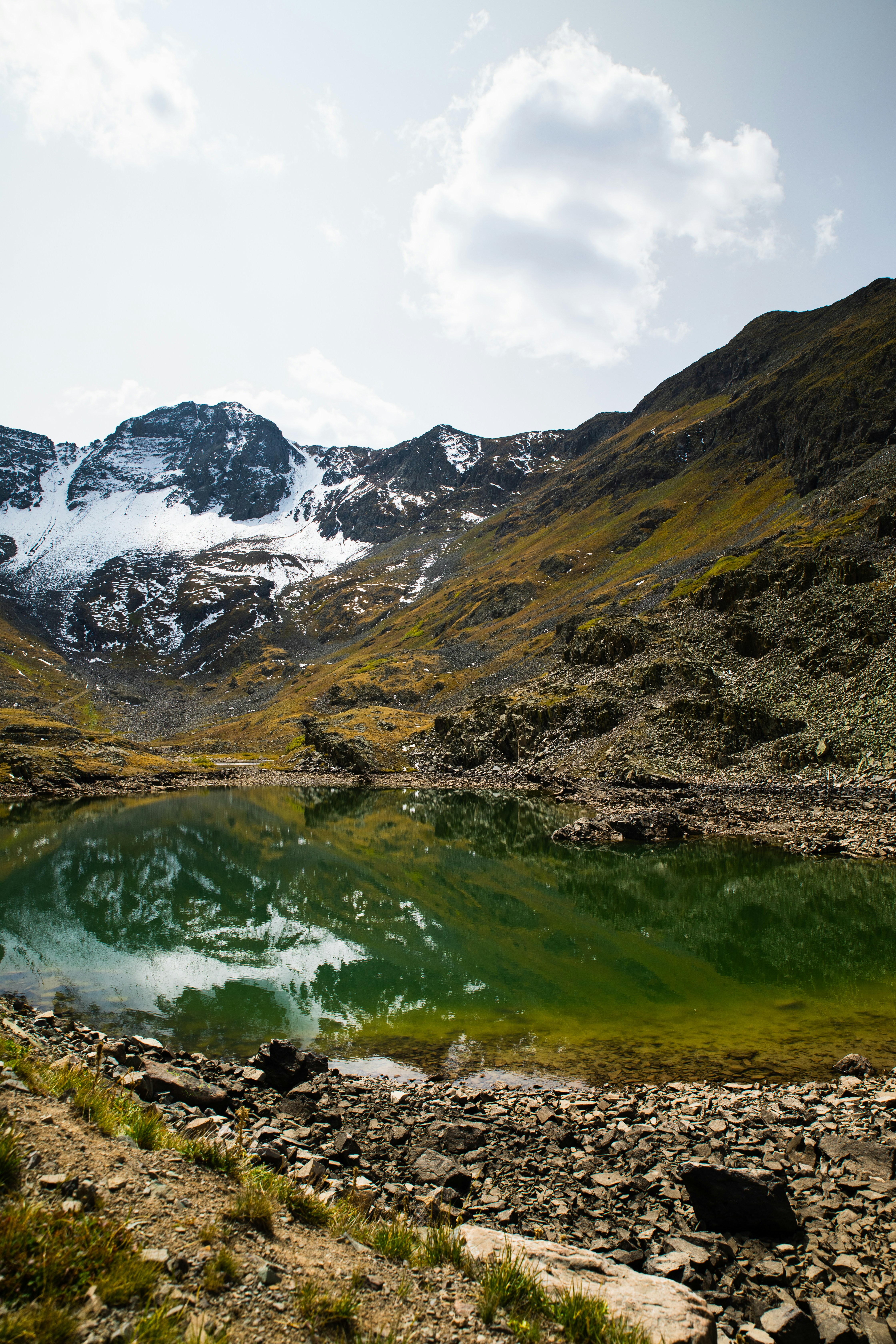 green and brown mountains near lake during daytime