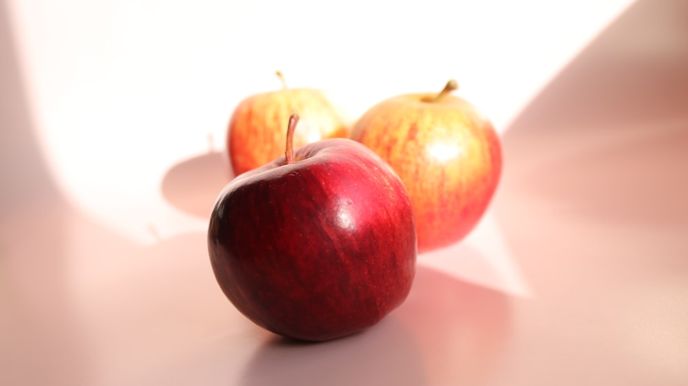 red apple fruit on white table