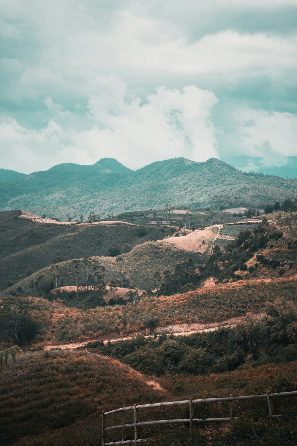 green and brown mountains under white clouds and blue sky during daytime