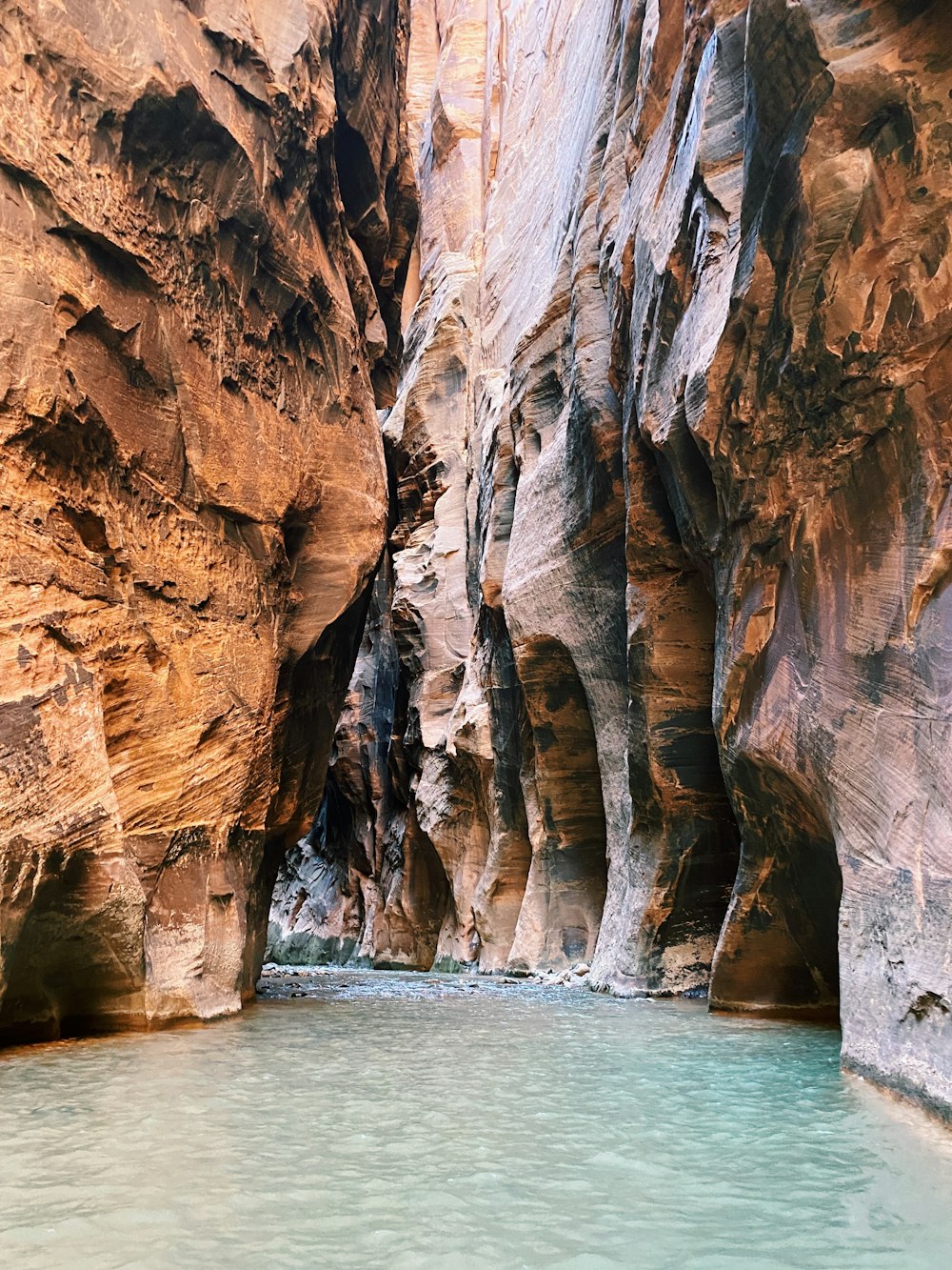 brown rock formation beside body of water during daytime