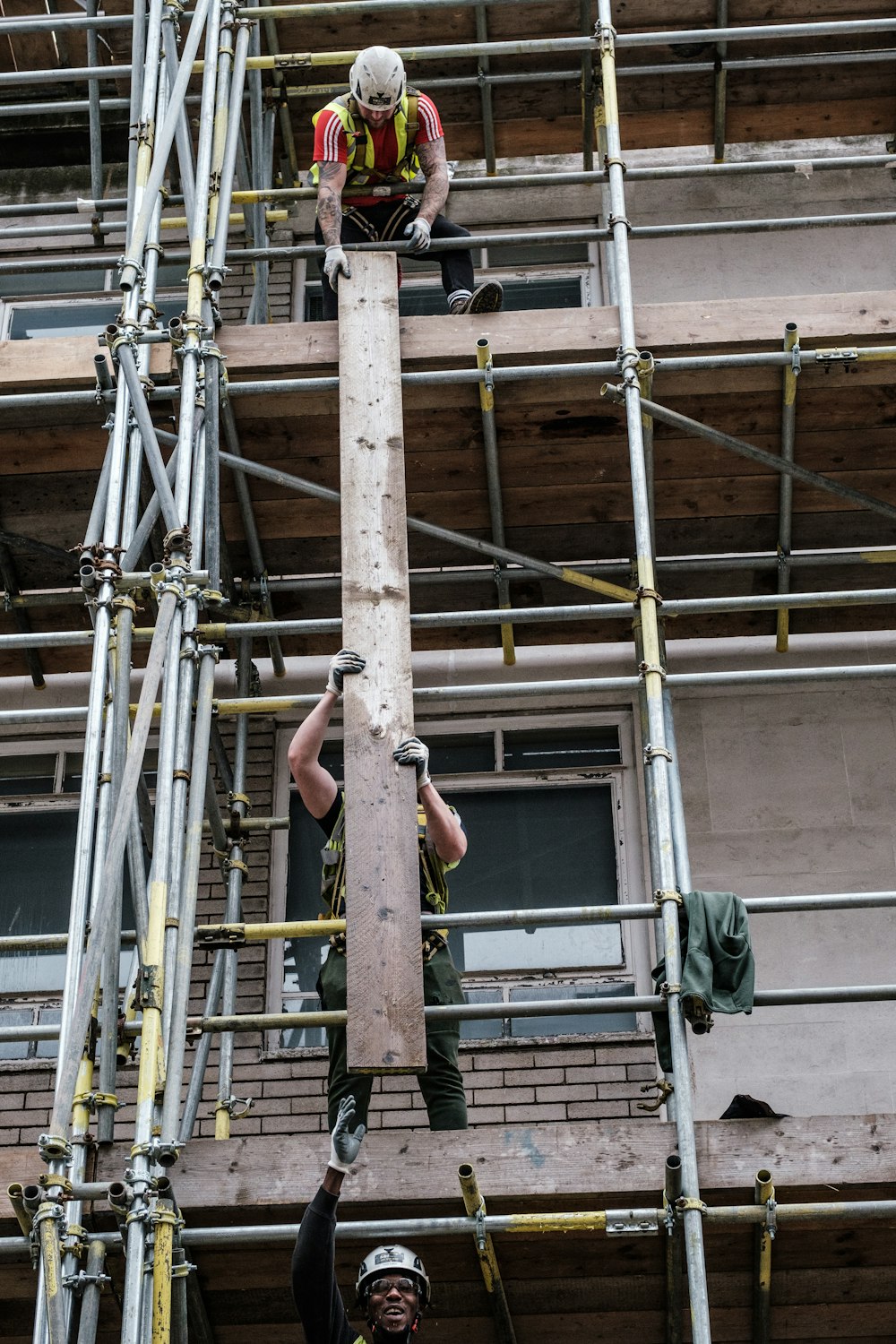 man in black shorts on brown metal ladder