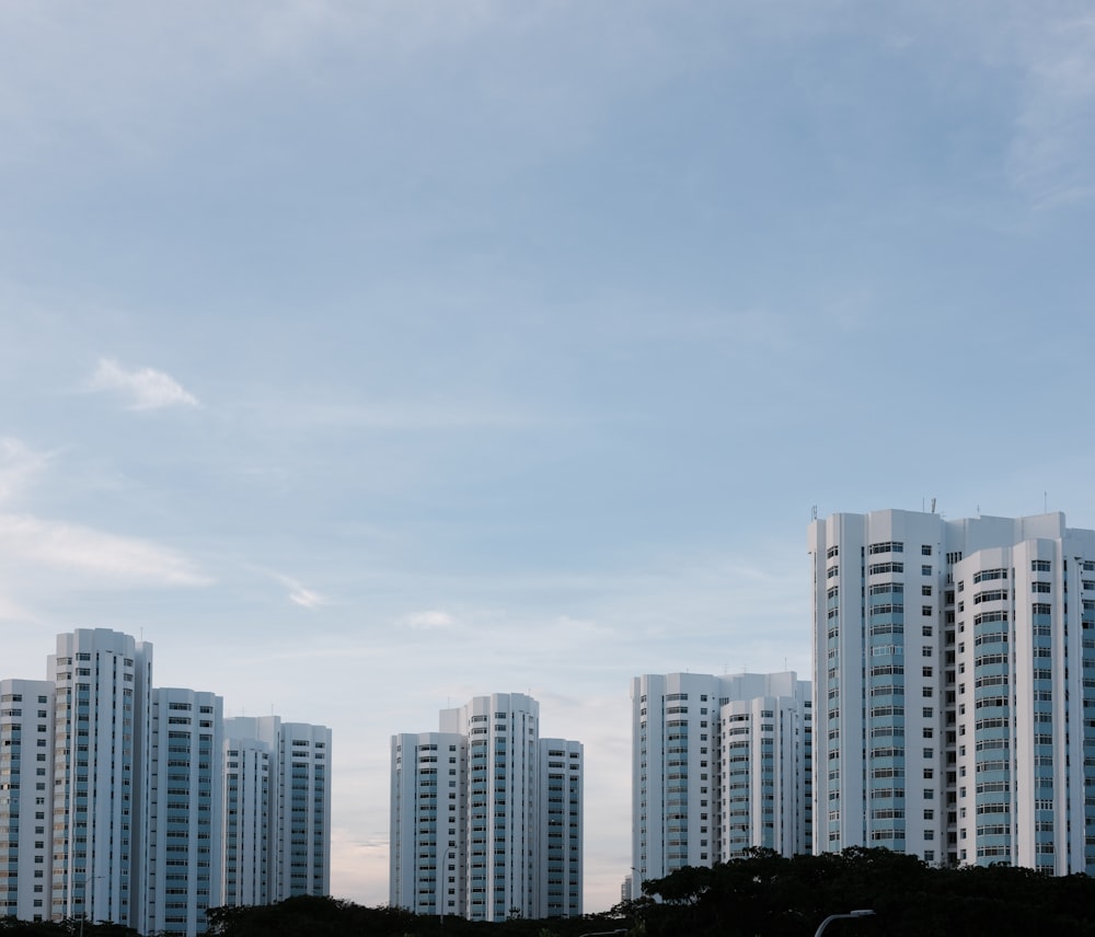 white and gray concrete buildings under white clouds during daytime