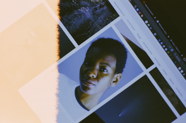 A computer screen displays a collage of images, including one of a person looking directly at the camera. The display has a noticeable light leak effect, creating a vintage or artistic appearance.