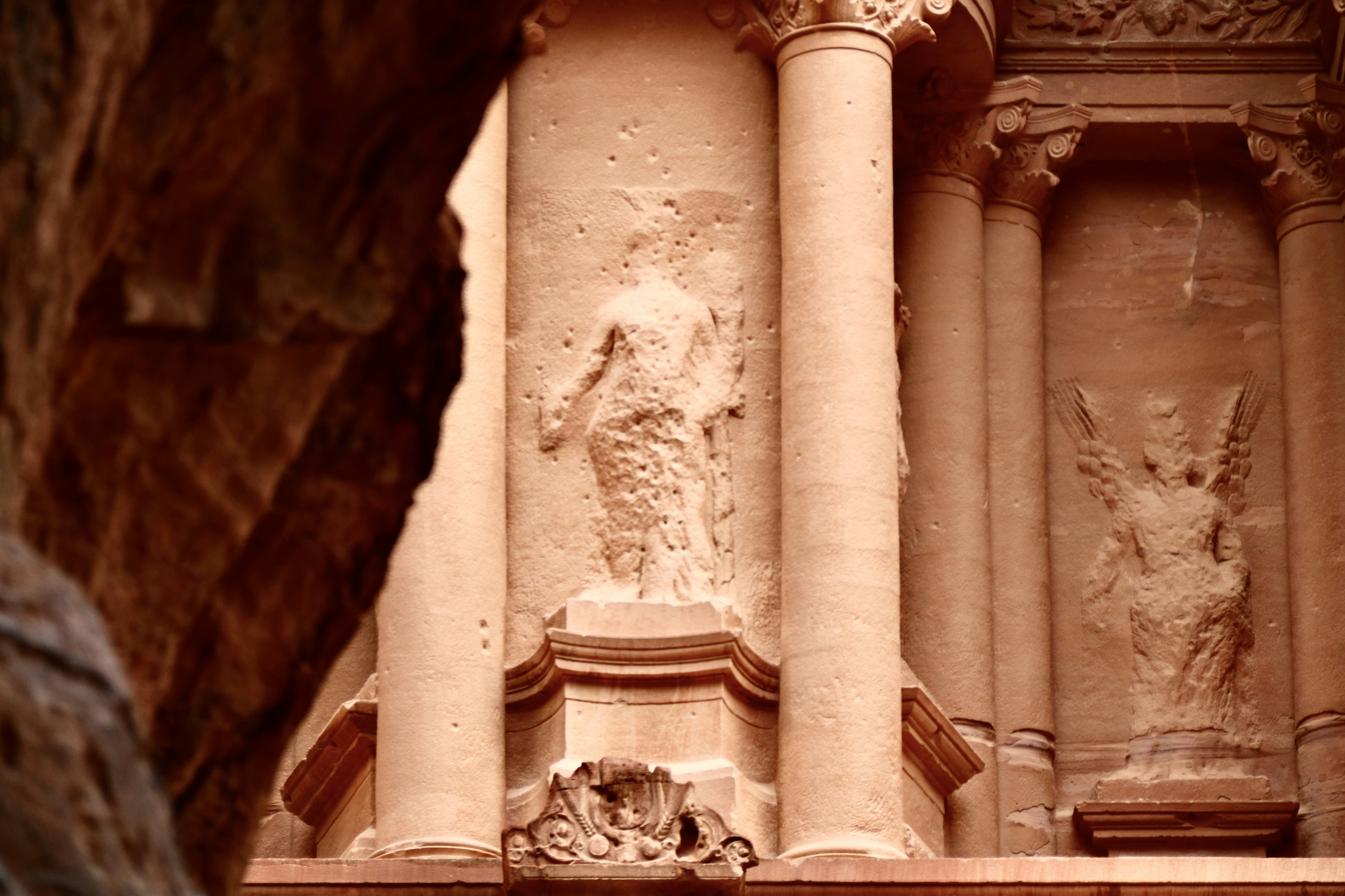 low angle photography of concrete building, Petra - Wadi Musa, Jordan 🇯🇴 Petra es un importante enclave arqueológico en Jordania, y la capital del antiguo reino nabateo, cuyos pobladores la llamaban Raqmu .1 El nombre de Petra proviene del griego πέτρα que significa piedra, y su nombre es idóneo ya que no se trata de una ciudad construida con piedra, si no literalmente excavada y esculpida en la piedra. El asentamiento de Petra se localiza en un valle angosto, al este del valle de la Aravá que se extiende desde el mar Muerto hasta el Golfo de Aqaba. Los restos más célebres de Petra son sin duda sus construcciones labradas