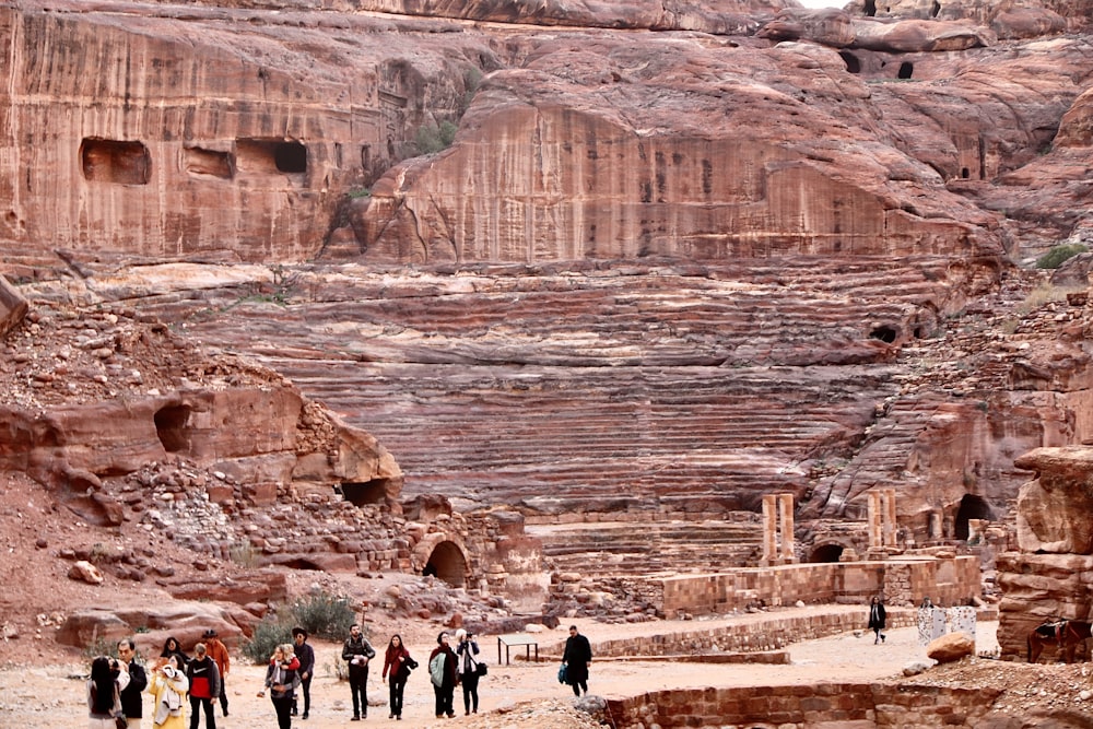 people walking on brown rock formation during daytime