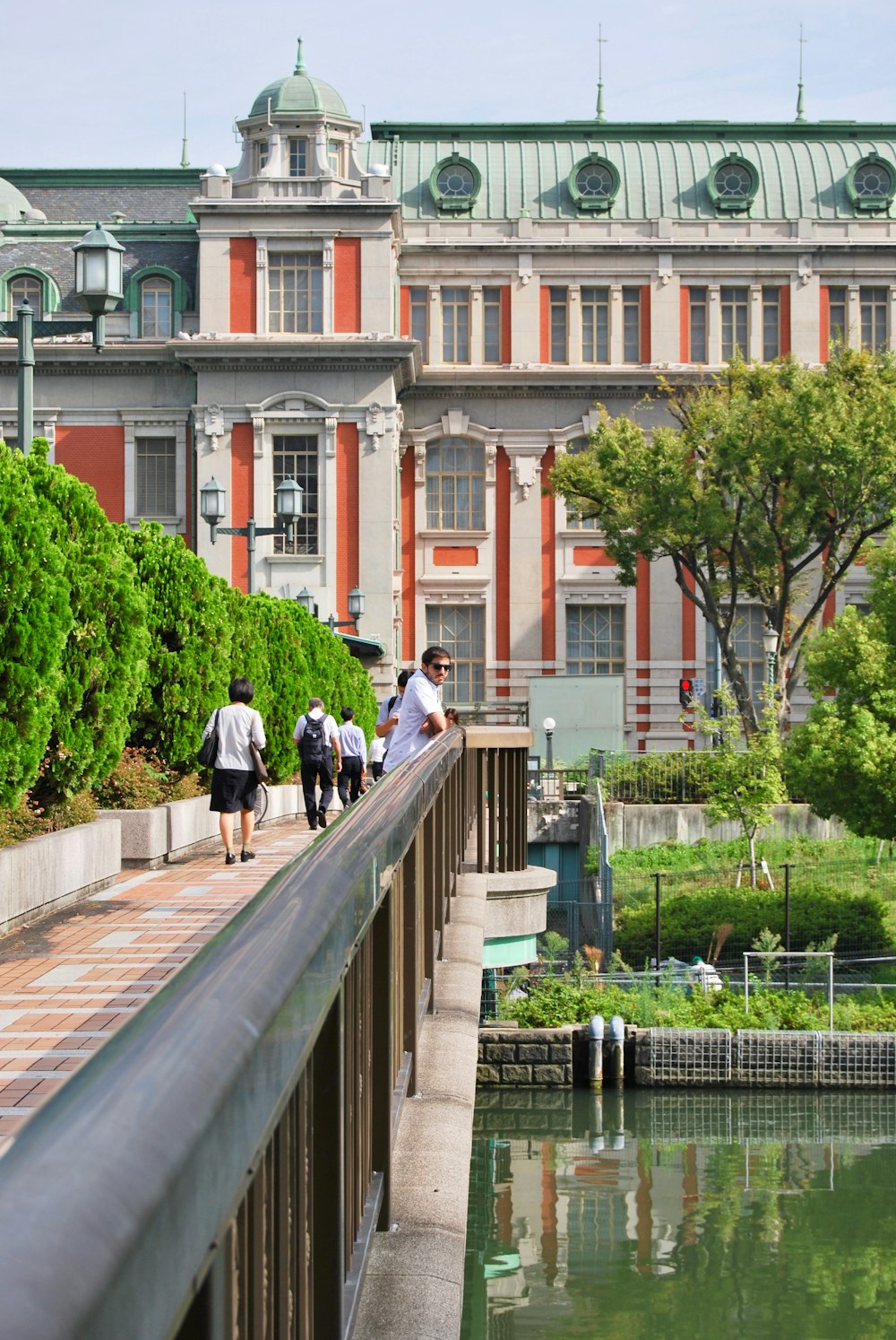 man in white dress shirt and black pants walking on gray concrete bridge during daytime