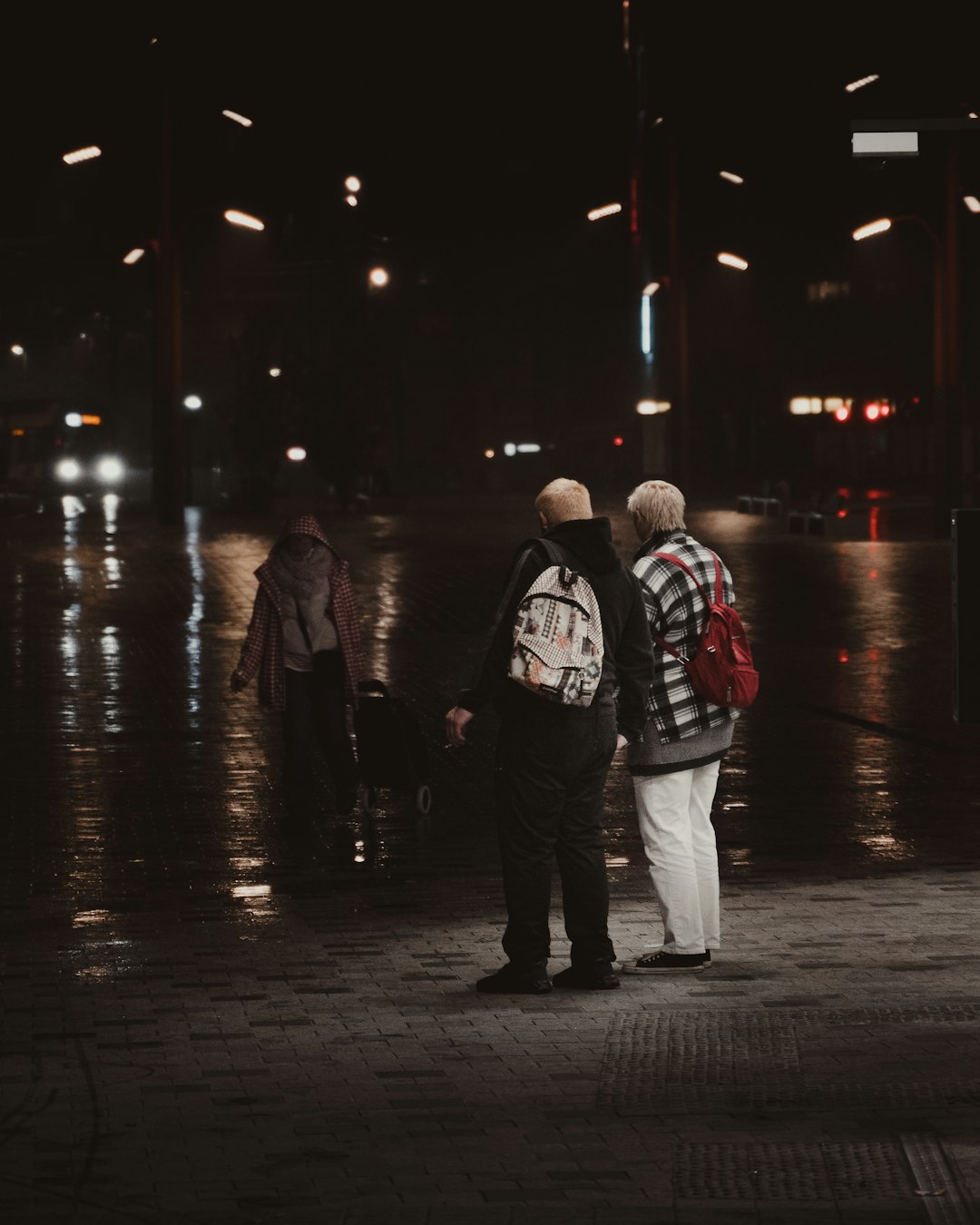man in black and white jacket standing beside man in black jacket during night time