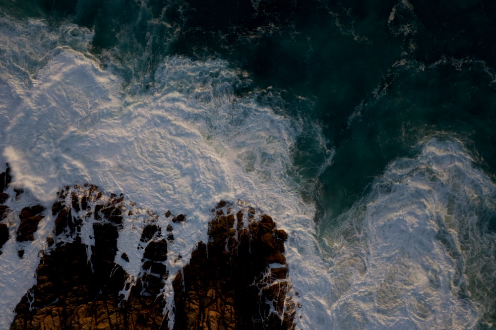 brown rock formation on body of water