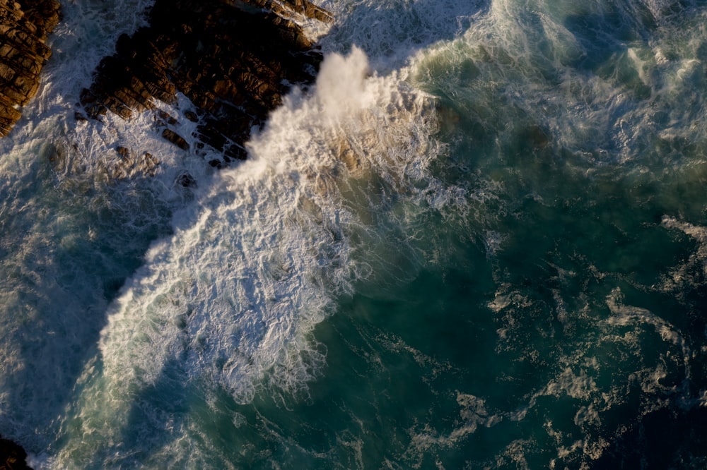 ondas do oceano batendo na costa rochosa durante o dia