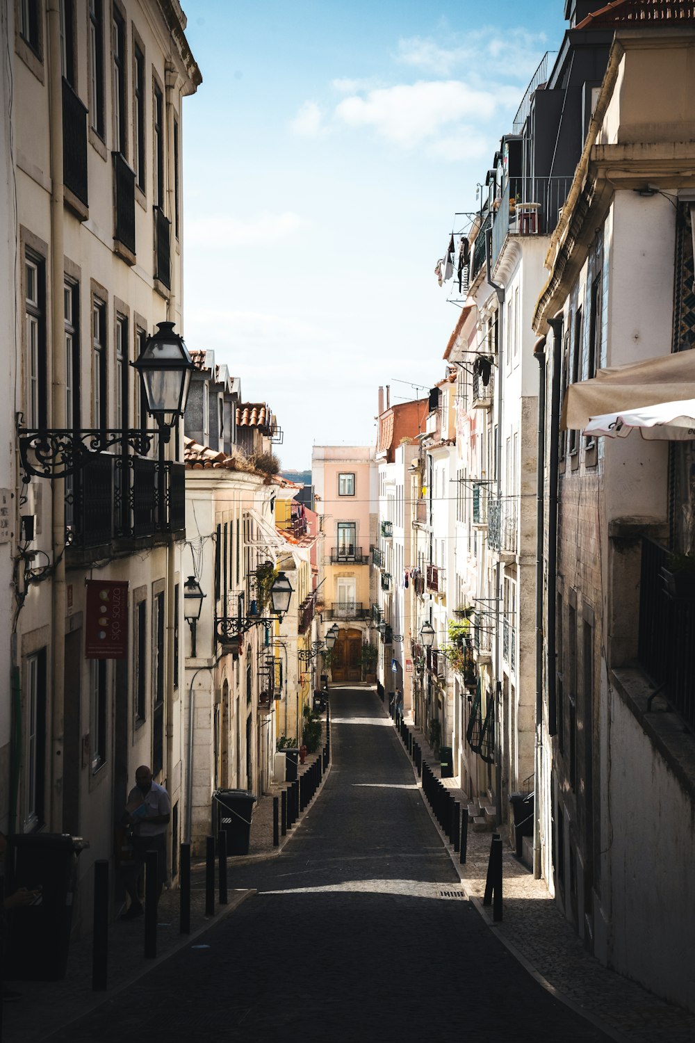 persone che camminano per strada tra gli edifici durante il giorno