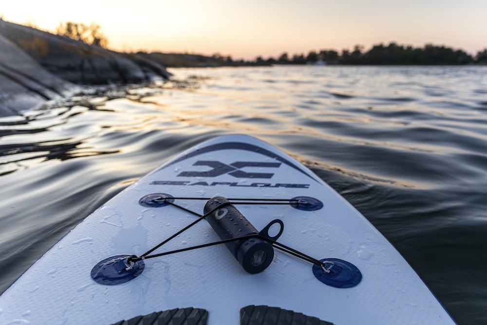 white and black surfboard on body of water during daytime