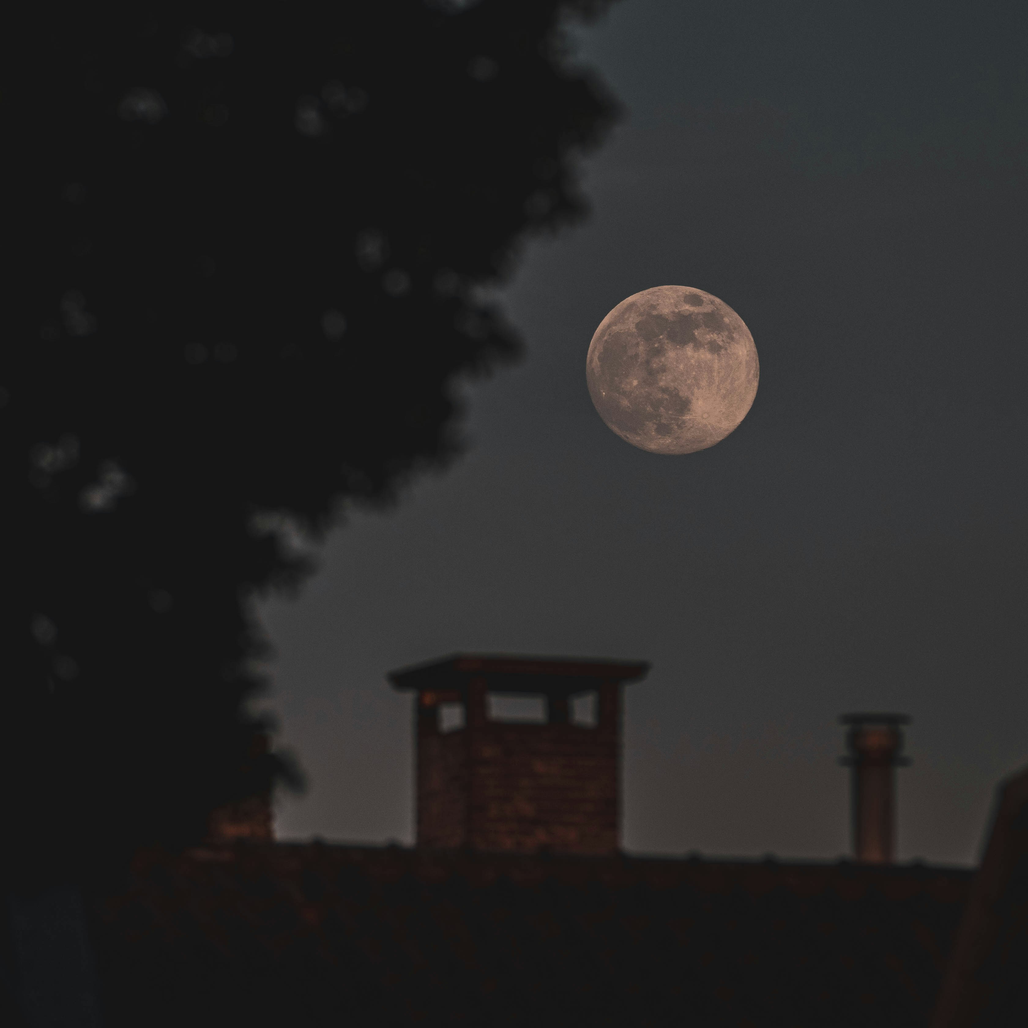 full moon over the silhouette of house