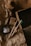 A rustic arrangement featuring eco-friendly toothbrushes made of wood and a jar of activated charcoal toothpaste. The items rest on crumpled brown paper, giving a natural and organic feel, with a background of cardboard and a textured fabric.