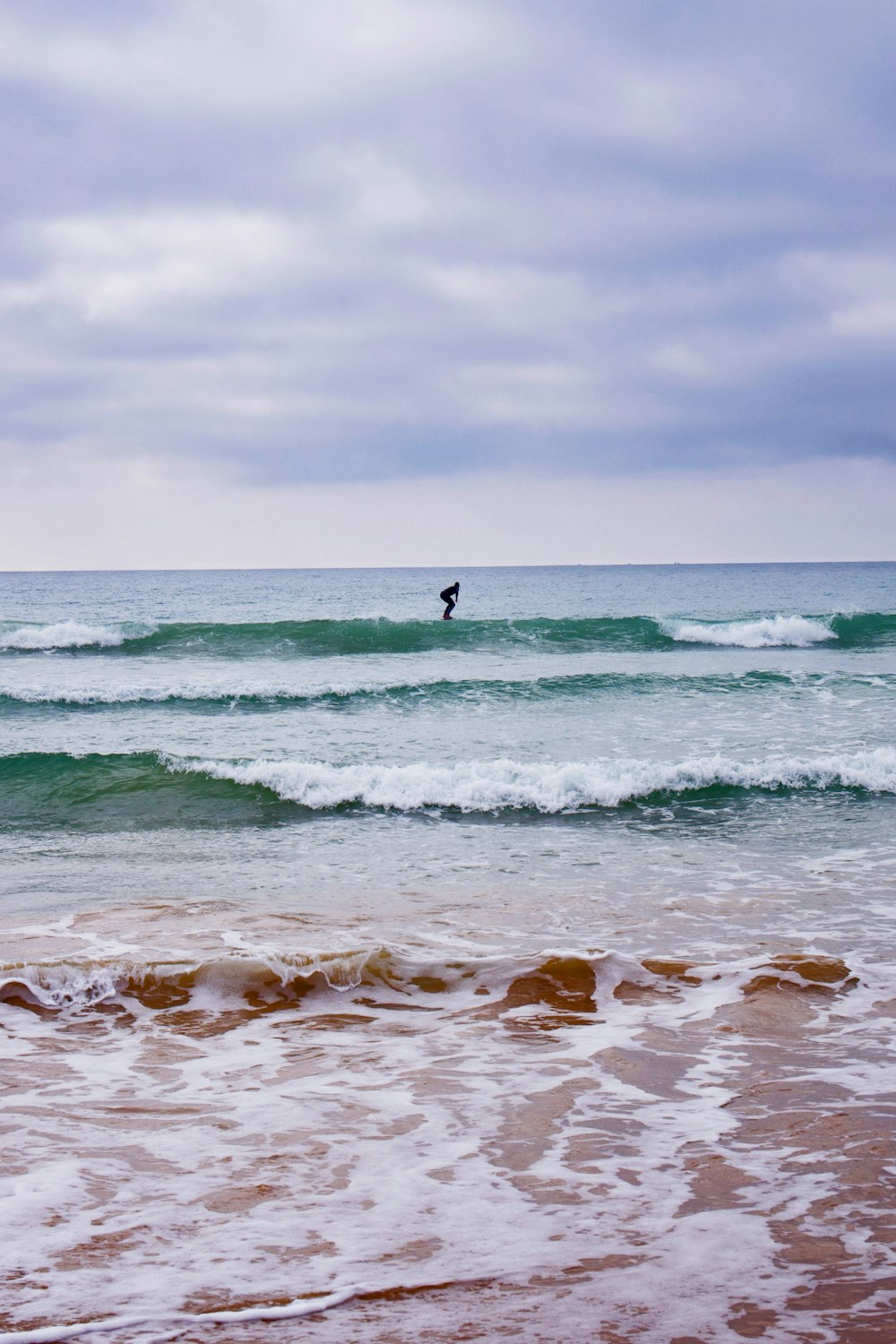 person surfing on sea waves during daytime