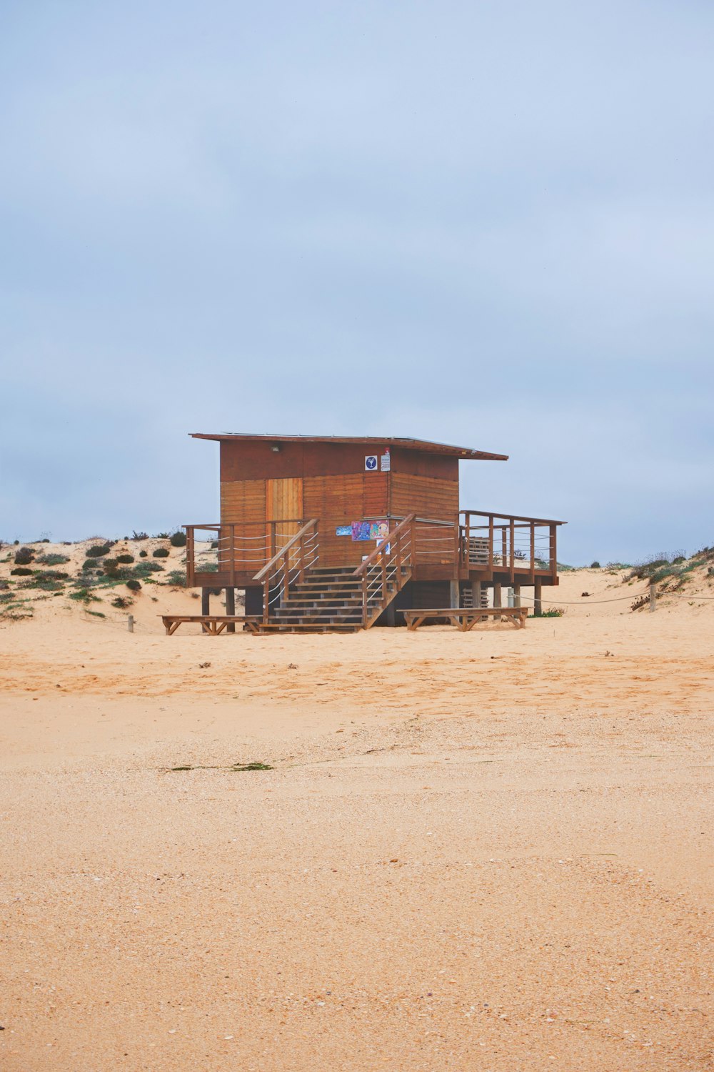 casa di legno marrone su sabbia marrone durante il giorno