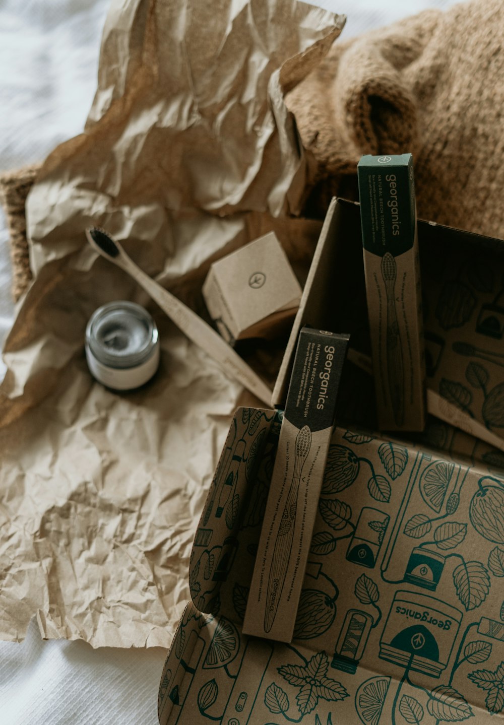 Caja en blanco y negro junto a taza de cerámica blanca sobre textil floral blanco y azul