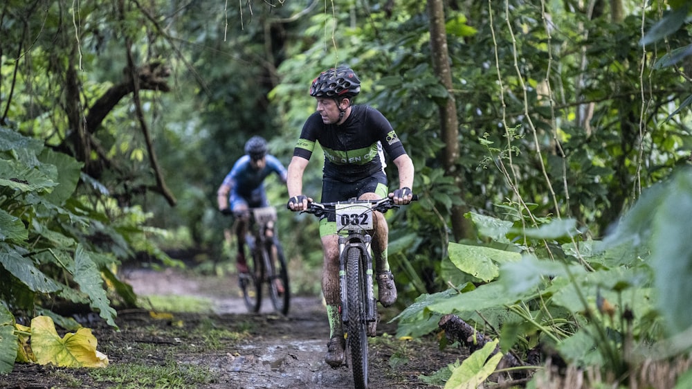 man in black t-shirt riding bicycle on dirt road during daytime