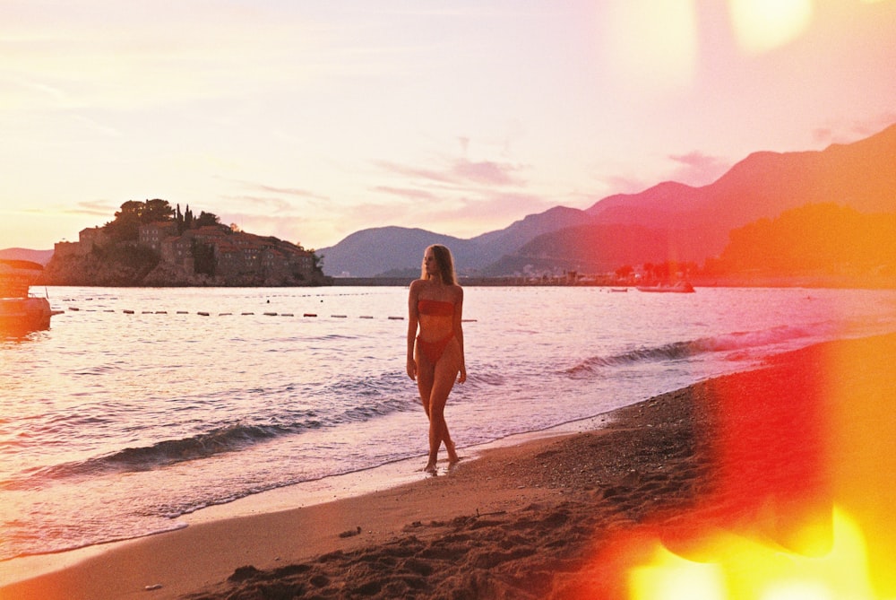 woman in white bikini standing on beach during sunset