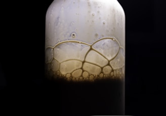 Close-up of a clear bottle of dishwashing liquid with bubbles reflecting light.