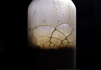 Close-up of a vibrant bottle of liquid detergent with fresh bubbles around it