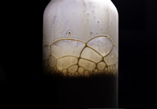 Close-up of a clear bottle of dishwashing liquid with bubbles reflecting light.