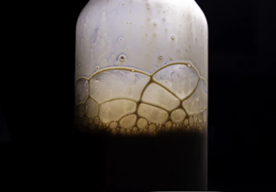 Close-up of sparkling soda bubbles rising in a clear bottle with a vibrant label.