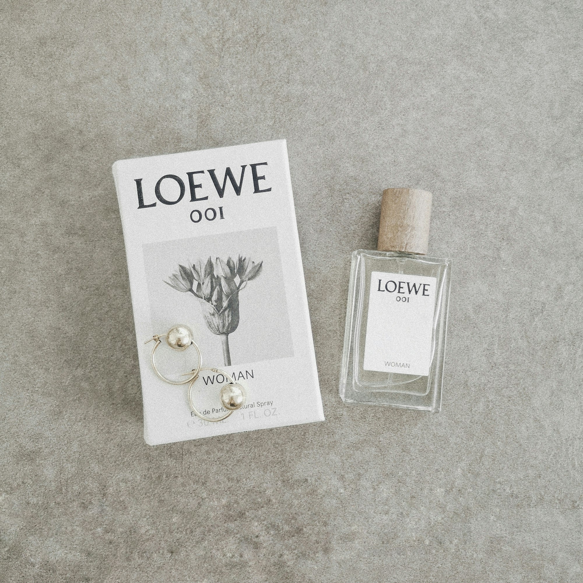 Loewe fragrance with gold earrings.