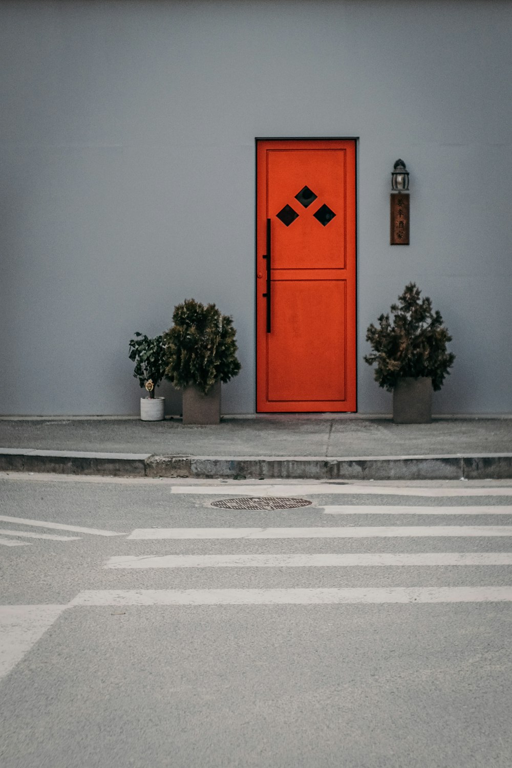 puerta de madera roja sobre pared de hormigón gris