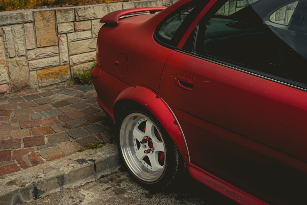 red car parked on gray concrete pavement