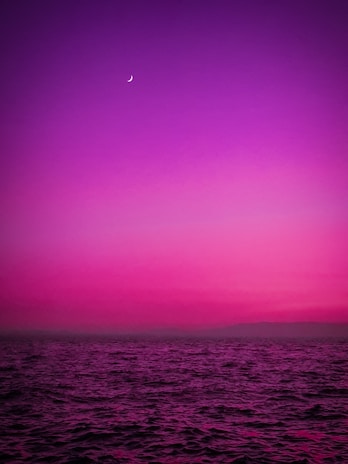 A glowing pastel neon moon intertwined with ocean waves under a starry sky.