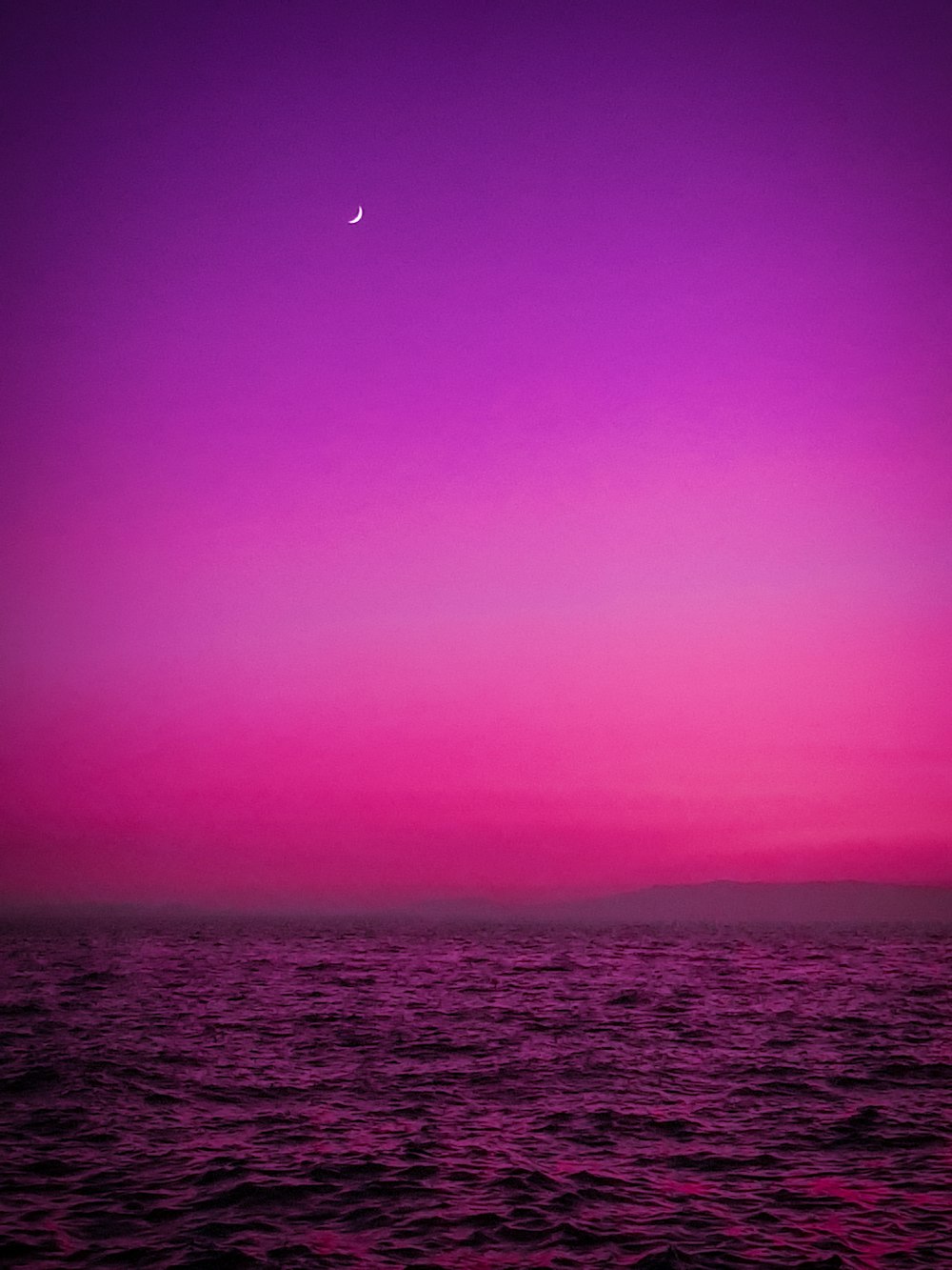body of water under purple sky