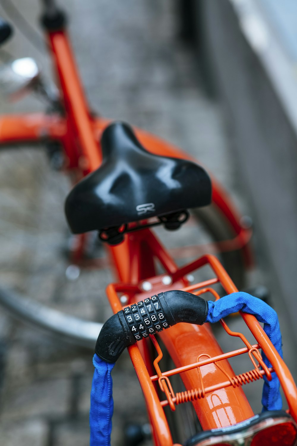 person in blue denim jeans riding on orange bicycle