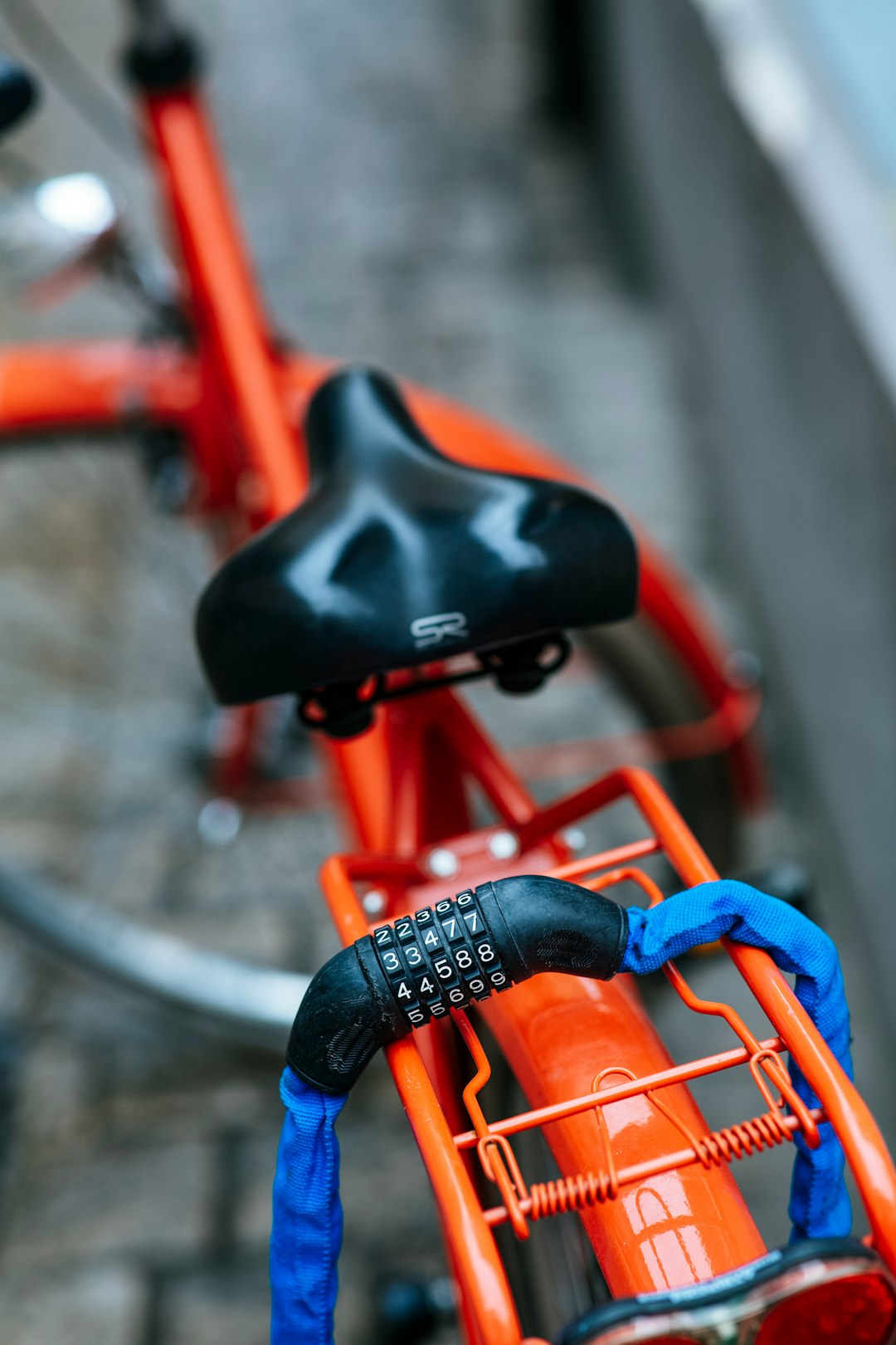 person in blue denim jeans riding on orange bicycle