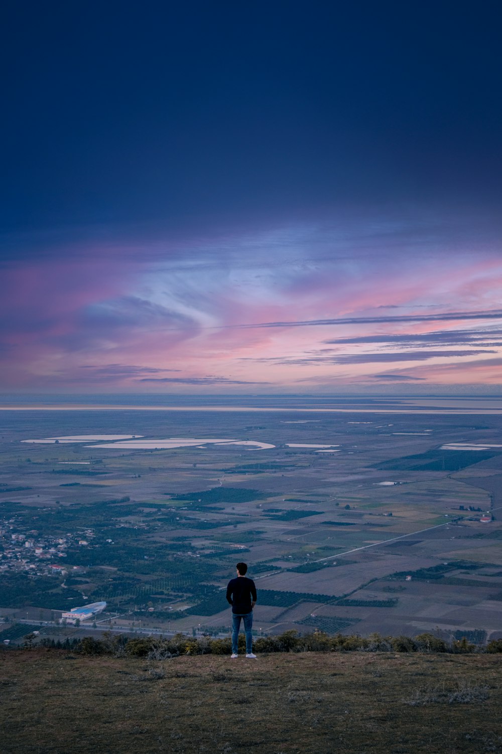 person in black jacket standing on top of the mountain during daytime