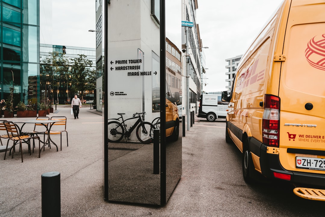 white van parked beside white concrete building during daytime